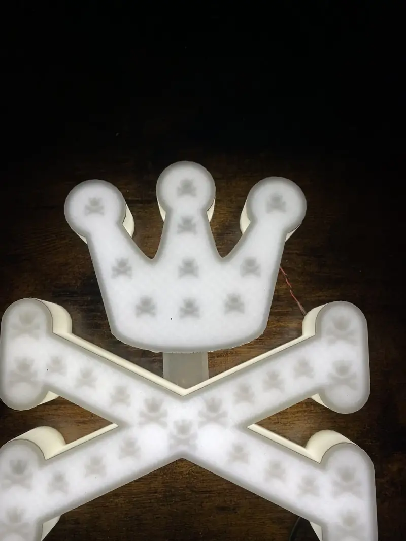 Logo couronne et os rétroéclairé en blanc